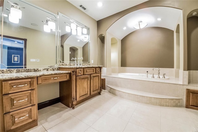 bathroom with vanity, tile floors, and tiled tub