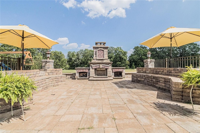 view of patio / terrace with a playground and an outdoor stone fireplace