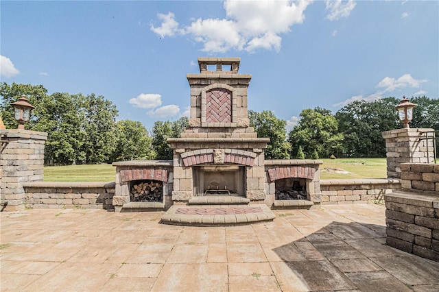 view of terrace featuring an outdoor stone fireplace