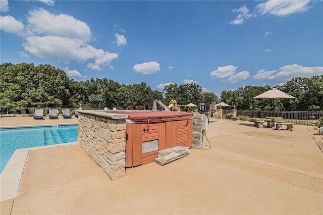 view of swimming pool with a patio area and a hot tub