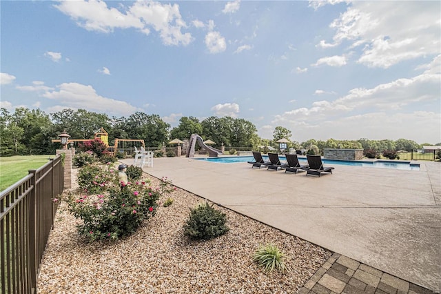 view of pool with a water slide and a patio area