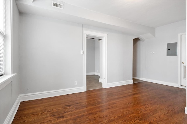 spare room with electric panel and dark hardwood / wood-style flooring