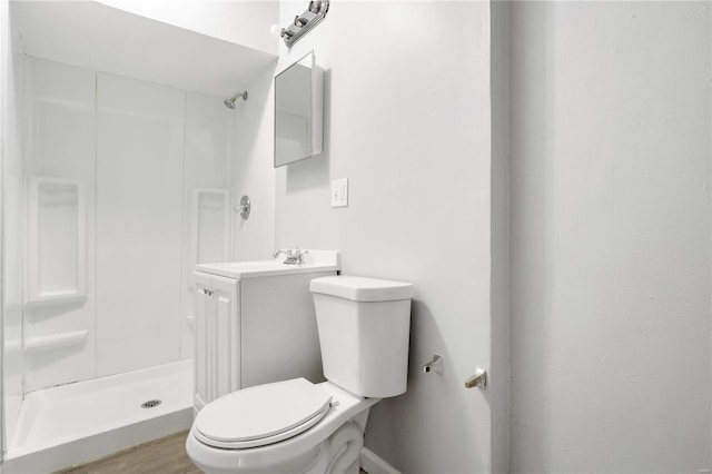 bathroom with vanity, hardwood / wood-style flooring, toilet, and walk in shower