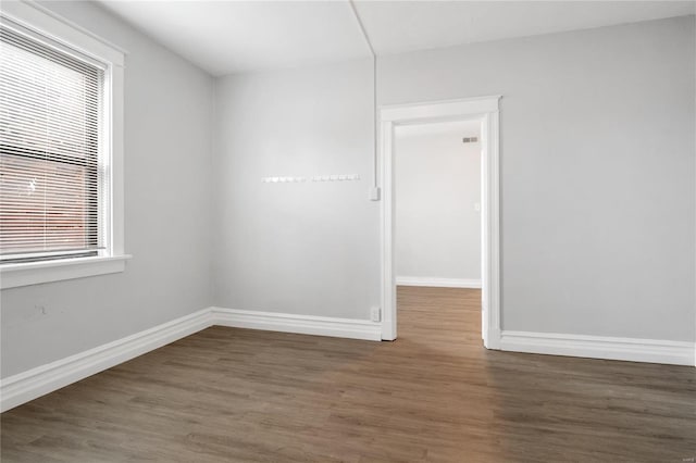 unfurnished room with dark hardwood / wood-style flooring