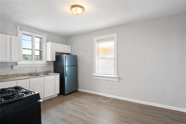 kitchen with white cabinetry, stainless steel refrigerator, plenty of natural light, and sink