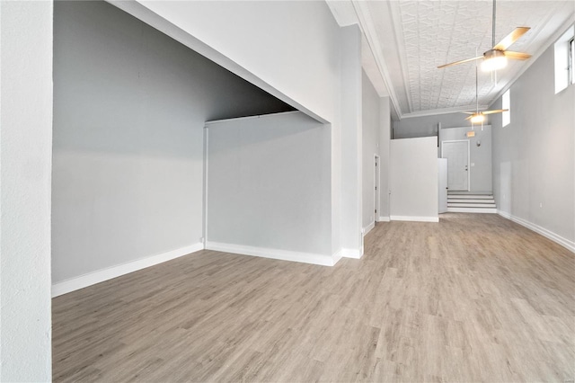 basement featuring light hardwood / wood-style flooring, ceiling fan, and ornamental molding