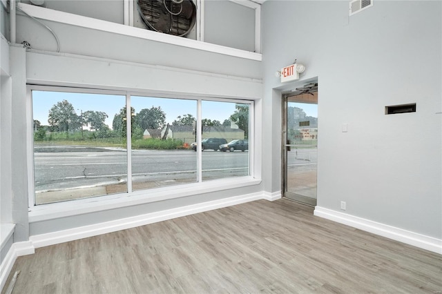 interior space featuring hardwood / wood-style flooring, ceiling fan, and a towering ceiling