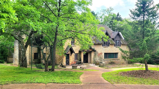 english style home featuring a front yard