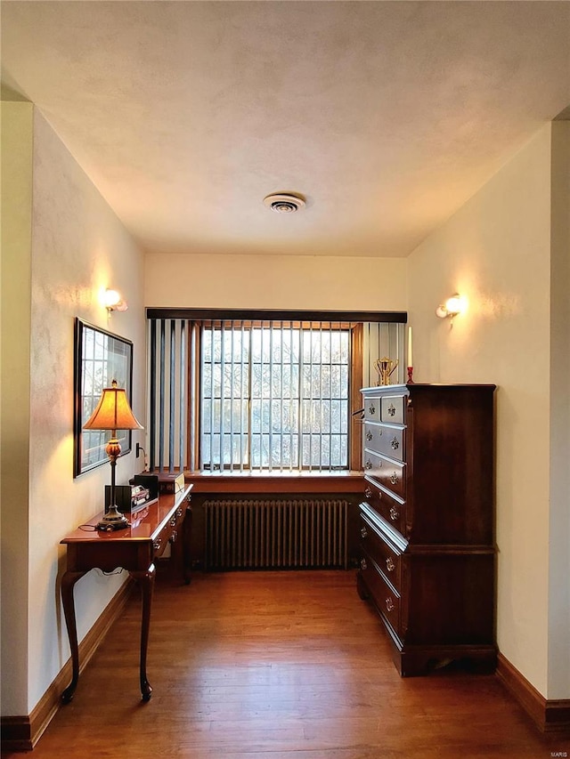 interior space featuring radiator heating unit and wood-type flooring