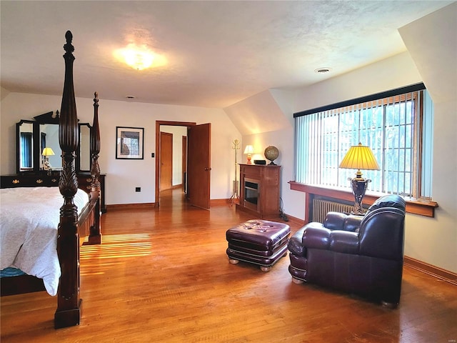 bedroom with wood-type flooring and vaulted ceiling