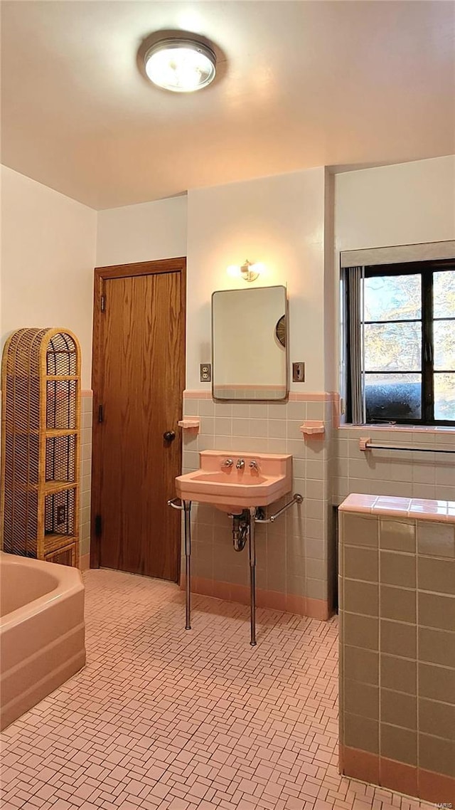 bathroom with a bath and tile walls