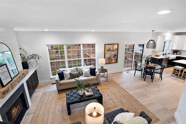 living room featuring sink and light hardwood / wood-style flooring