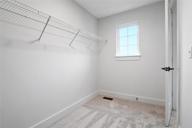 walk in closet featuring light carpet