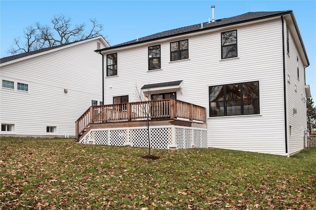 rear view of house featuring a deck and a lawn