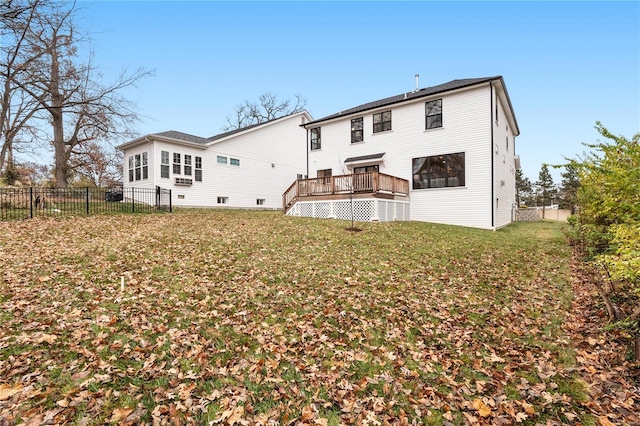 back of house featuring a wooden deck and a lawn