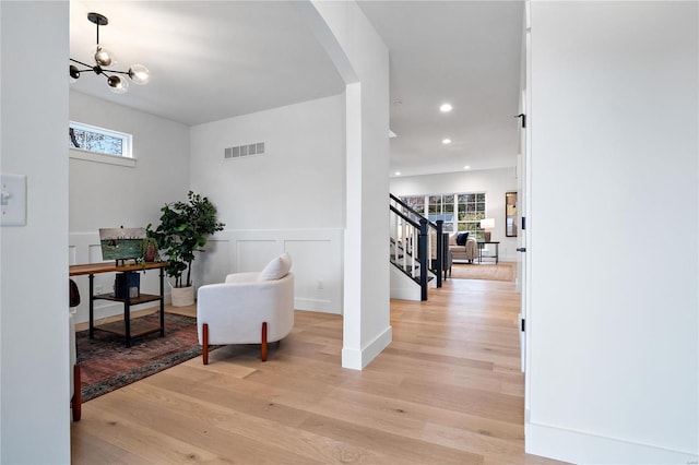 interior space with light hardwood / wood-style floors and a notable chandelier