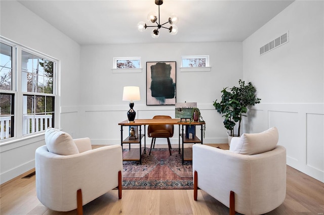 living area featuring a notable chandelier and light wood-type flooring