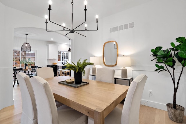 dining space featuring a chandelier and light wood-type flooring