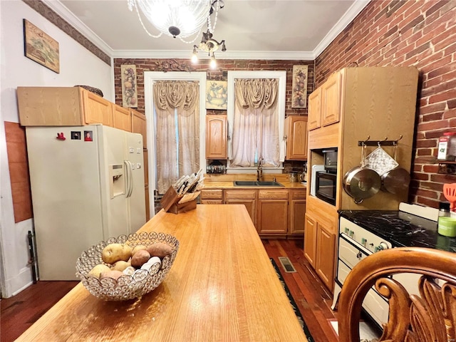 kitchen featuring dark wood-type flooring, white appliances, sink, a chandelier, and ornamental molding