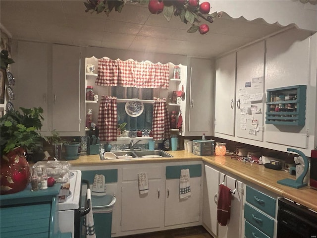 kitchen featuring dishwashing machine, white cabinetry, and sink