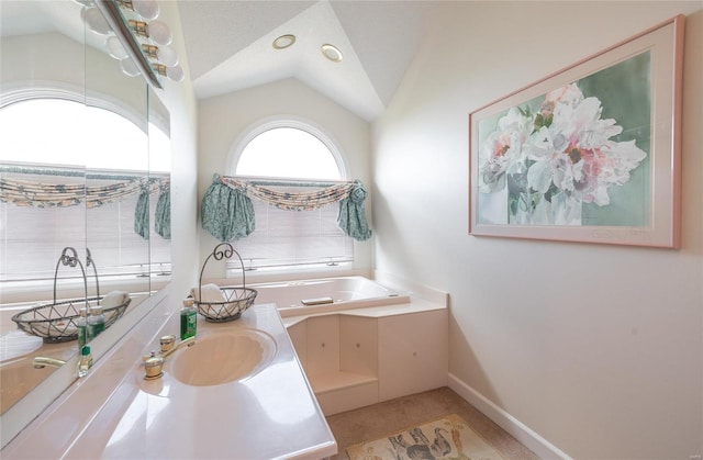 bathroom featuring lofted ceiling, vanity, a bathing tub, and tile floors