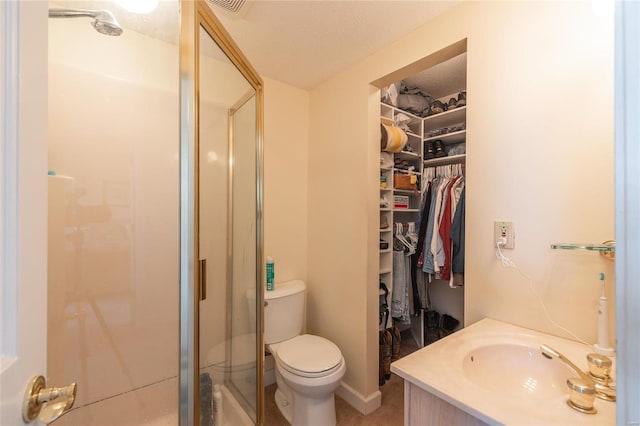 bathroom with a shower with door, a textured ceiling, toilet, and vanity