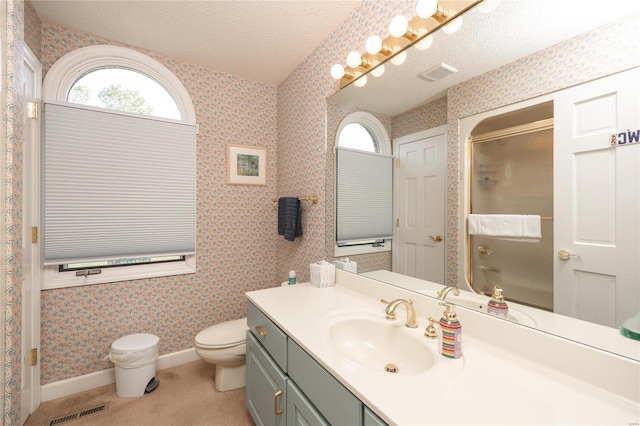 bathroom with toilet, vanity, and a textured ceiling