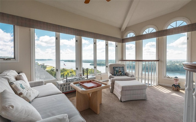 sunroom with ceiling fan, a water view, a wealth of natural light, and vaulted ceiling with beams