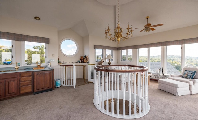 dining space with light carpet, vaulted ceiling, and ceiling fan with notable chandelier