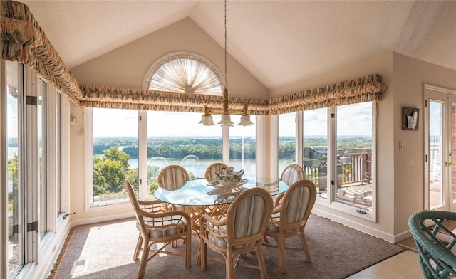 tiled dining area featuring high vaulted ceiling, a water view, and a textured ceiling