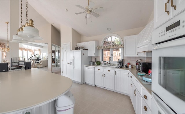 kitchen featuring white cabinets, white appliances, ceiling fan with notable chandelier, and a healthy amount of sunlight