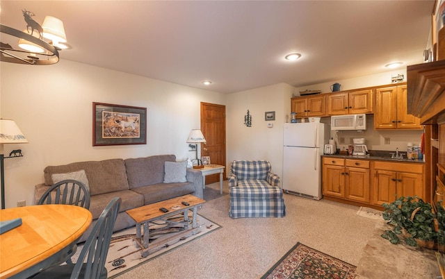 carpeted living room featuring sink and a chandelier