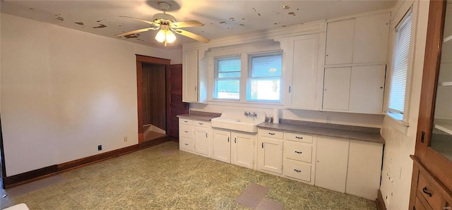 kitchen featuring ceiling fan, white cabinetry, sink, and light tile floors