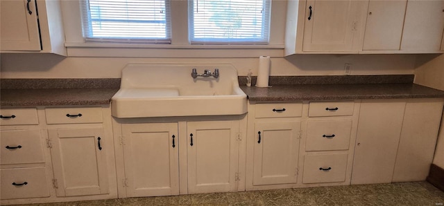 kitchen featuring white cabinetry and sink