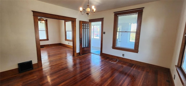 foyer entrance with an inviting chandelier and dark hardwood / wood-style flooring