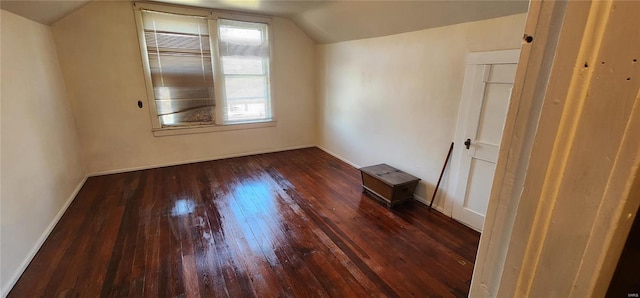 unfurnished room featuring lofted ceiling and dark hardwood / wood-style floors