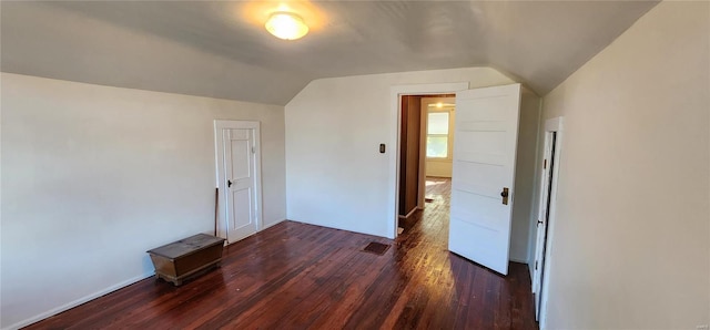 additional living space featuring vaulted ceiling and dark hardwood / wood-style flooring