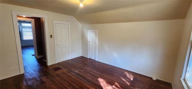 empty room featuring lofted ceiling and dark hardwood / wood-style floors