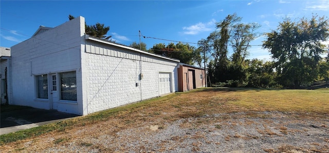 view of side of property with a garage and a lawn