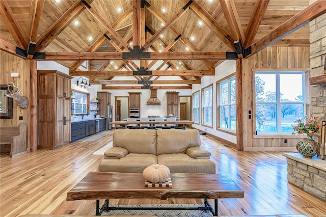 living room with light hardwood / wood-style floors, beam ceiling, and wood ceiling