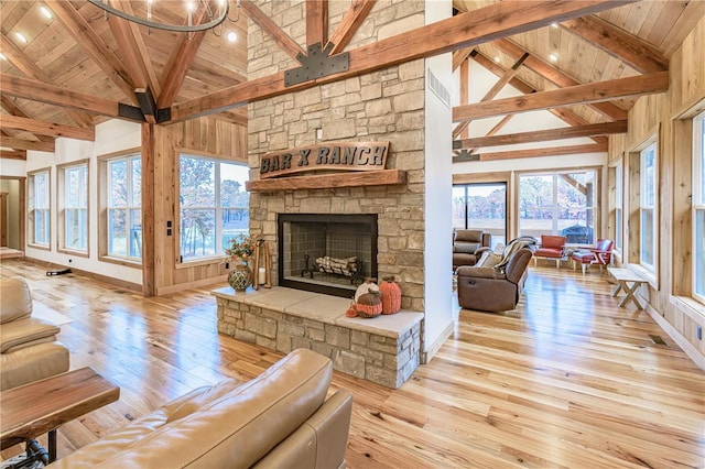 living room with high vaulted ceiling, light hardwood / wood-style flooring, and a healthy amount of sunlight