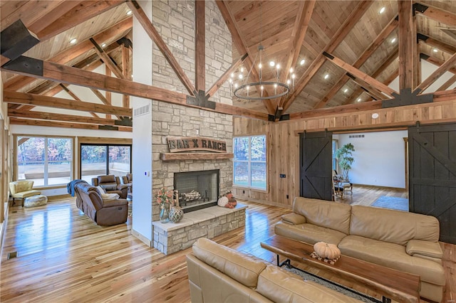 living room with a healthy amount of sunlight, hardwood / wood-style floors, and high vaulted ceiling