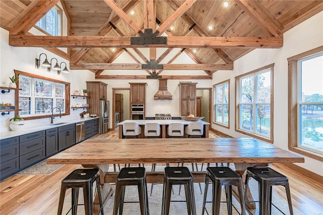 interior space featuring wooden ceiling, plenty of natural light, sink, beam ceiling, and light hardwood / wood-style floors