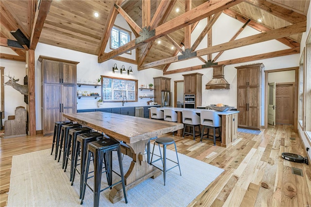 dining area with high vaulted ceiling, beamed ceiling, wooden ceiling, and light hardwood / wood-style flooring