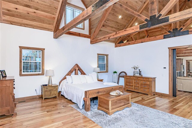 bedroom featuring beamed ceiling, wood ceiling, light wood-type flooring, and high vaulted ceiling