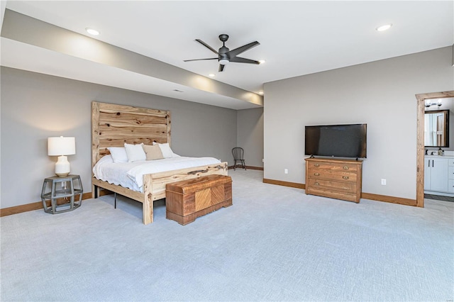 bedroom with light colored carpet, ensuite bathroom, and ceiling fan