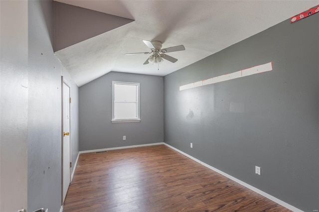 spare room featuring ceiling fan, vaulted ceiling, and dark hardwood / wood-style flooring