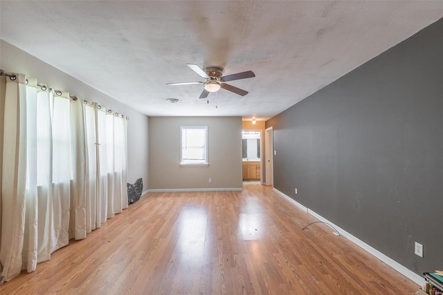 spare room featuring a textured ceiling, ceiling fan, and light hardwood / wood-style floors