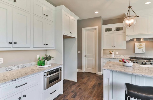 kitchen with white cabinets, oven, decorative light fixtures, and dark hardwood / wood-style floors