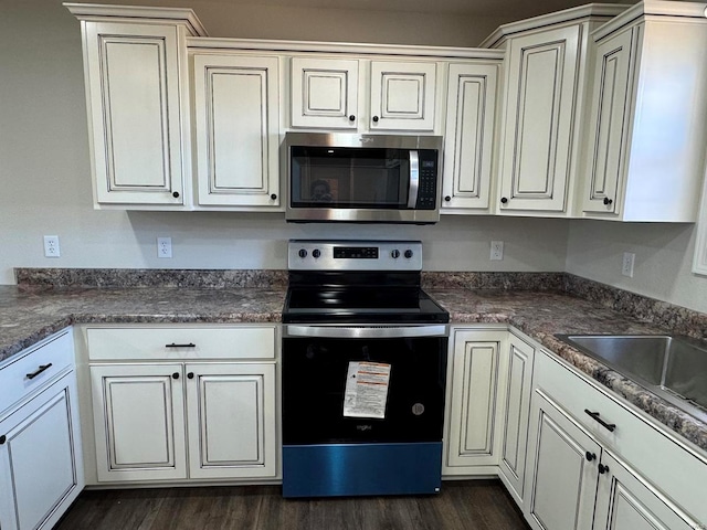 kitchen with stainless steel appliances, dark hardwood / wood-style floors, and white cabinetry